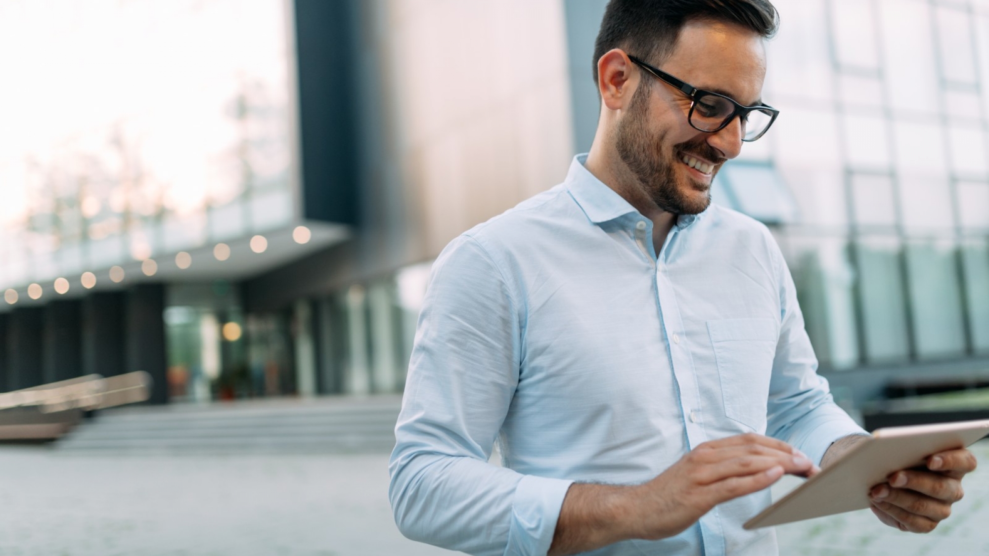 portrait-of-businessman-in-glasses-holding-tablet-AWVHCJ67U